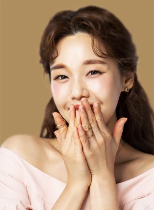 허쉬 리프팅부스터 — 두 손으로 입을 가리고 웃는 여성(금색 바탕)