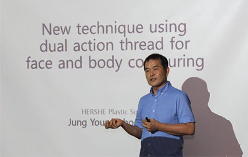 'New technique using dual action thread for face and body contouring' 슬라이드 앞에서 강연하는 의사